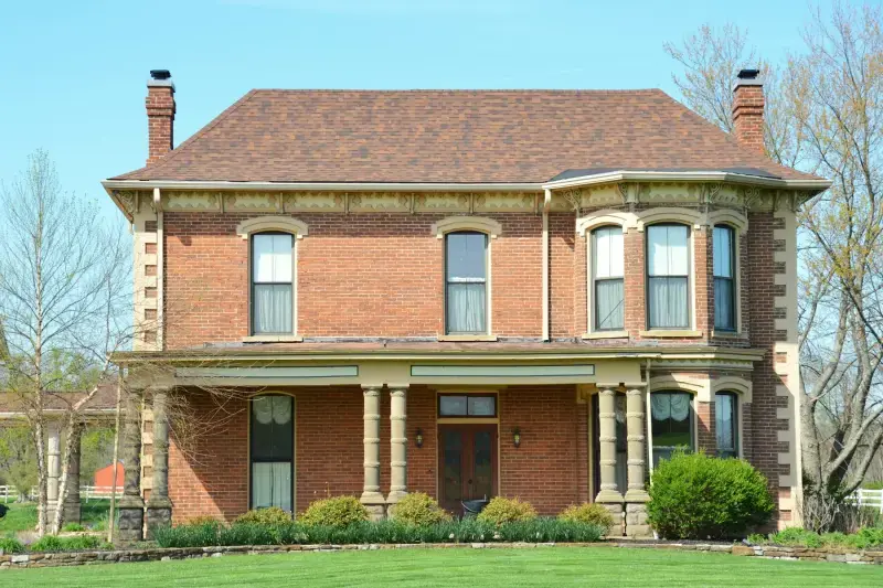Red-brick Victorian house with a wide front porch
