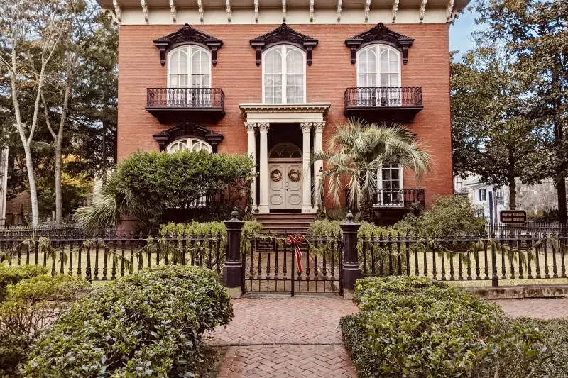 Two-story Italianate brick house with iron balconies