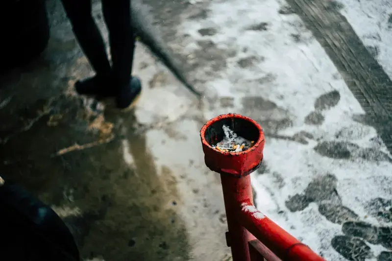 Water welling up out of a red outdoor pipe fitting